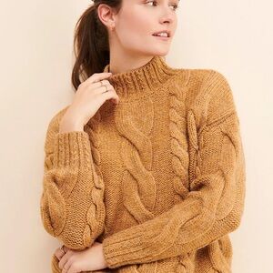 Chunky cable knit mock neck sweater with low shoulders and fitted wrist.